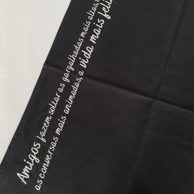 Pano preto com bordado branco com frase em Português.