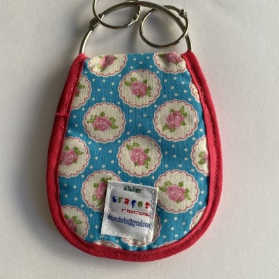 Chaveiro em tecido floral com bordas vermelhas e argolas metálicas prateadas