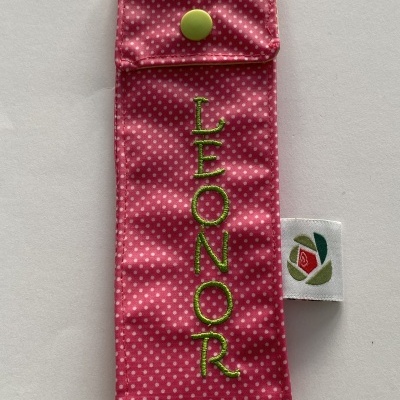 Estojo rosa com bolinhas brancas e nome LEONOR bordado a verde