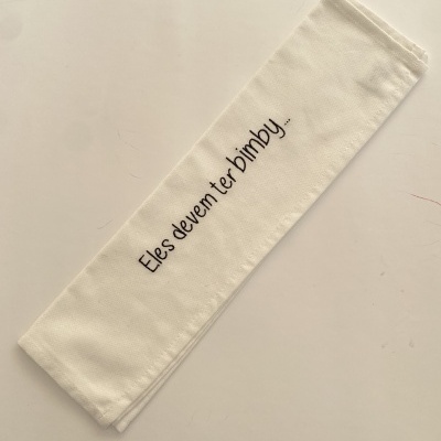 Guardanapo branco com bordado a preto com a frase Eles devem ter bimby..