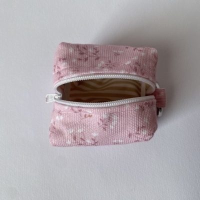 Bolsa de tecido rosa com fecho de correr aberta e padrão floral