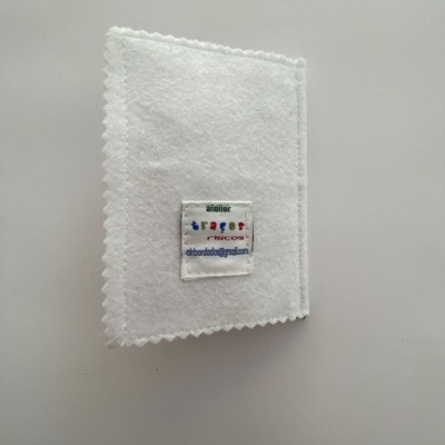 Capa branca de feltro com etiqueta colorida em fundo branco