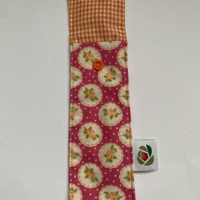 Estojo de tecido com botão e padrões florais e xadrez