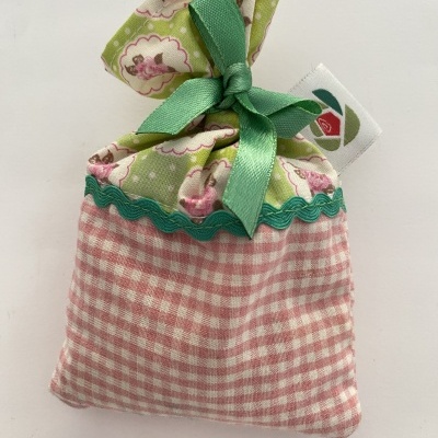 Saquinho perfumado em tecido com padrões rosa e verde e fita verde.
