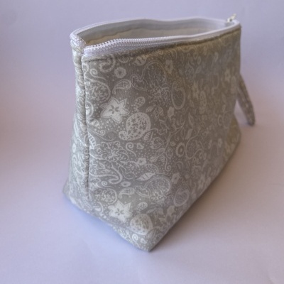 Necessaire cinza com padrão floral branco e fecho de correr