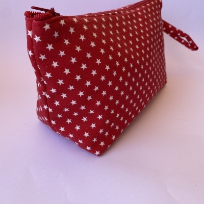 Estojo vermelho com estrelas brancas e fecho vermelho