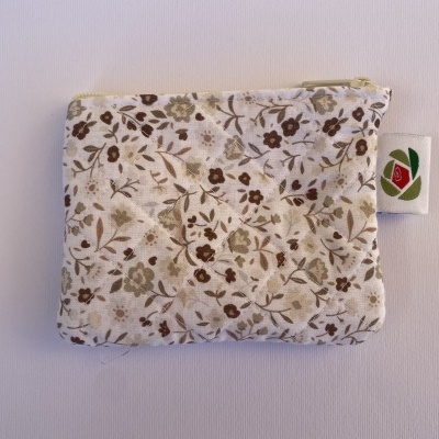 Bolsa pequena florida em tecido com fecho amarelo e etiqueta floral