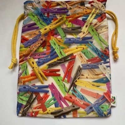 Saco de tecido com padrão de molas de roupa coloridas e cordão amarelo