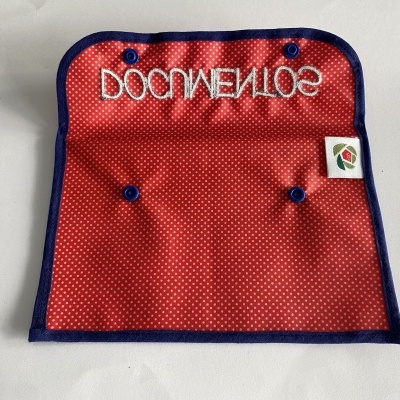 Bolsa de tecido vermelho com pontos brancos e bordas azuis com texto invertido