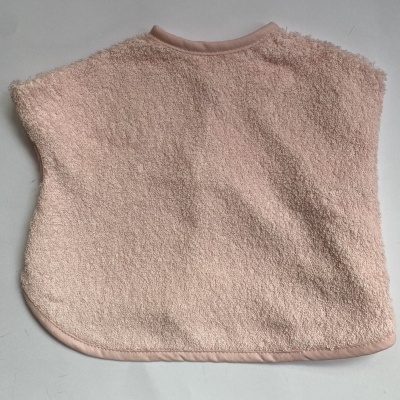 Capa ou poncho para bebé rosa em tecido felpudo sobre superfície branca