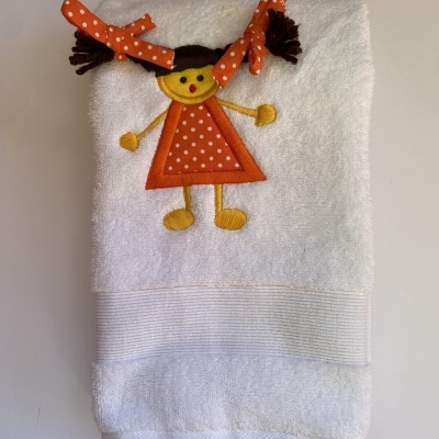 Toalha branca com bordado de menina de vestido laranja às bolinhas e laços no cabelo