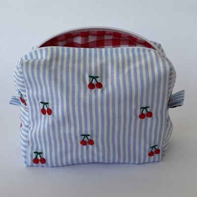 Necessaire azul às riscas com bordados de cerejas e interior xadrez vermelho e branco