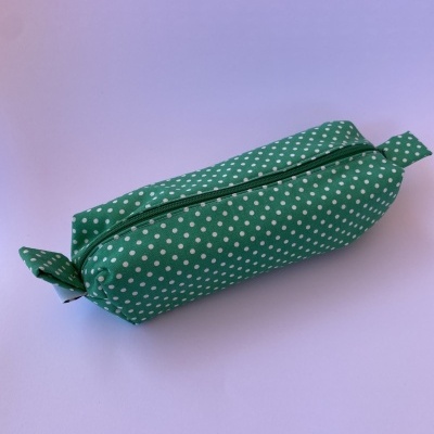 Estojo verde com bolinhas brancas e fecho de correr