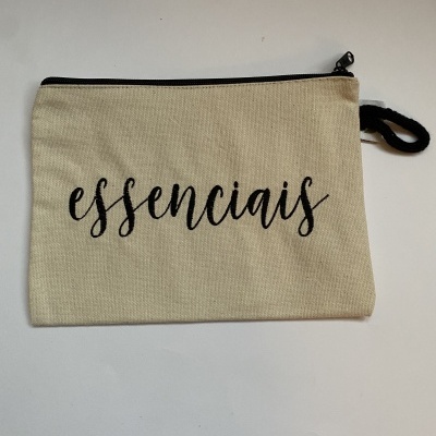 Bolsa de tecido bege com fecho preto e a palavra essenciais escrita na frente.
