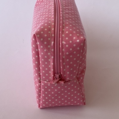 Estojo rosa com bolinhas brancas e fecho de correr