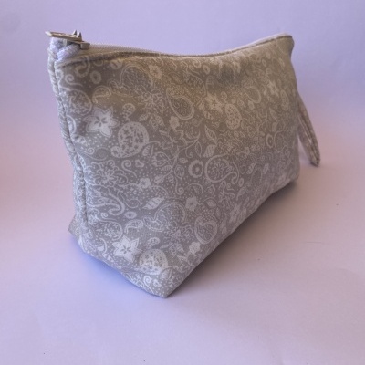 Estojo cinzento com padrão floral branco e fecho metálico