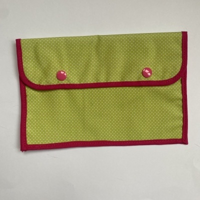 Bolsa ou carteira verde com pontos brancos e bordas cor-de-rosa