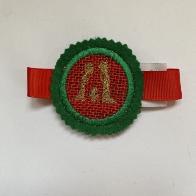 Prendedor de fita vermelho com decoração circular em feltro verde e tecido vermelho dourado