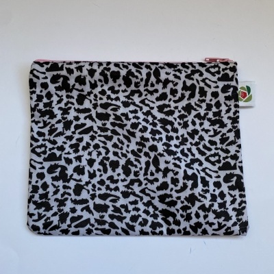 Mala pequena com padrão animal print preto e branco e fecho cor-de-rosa