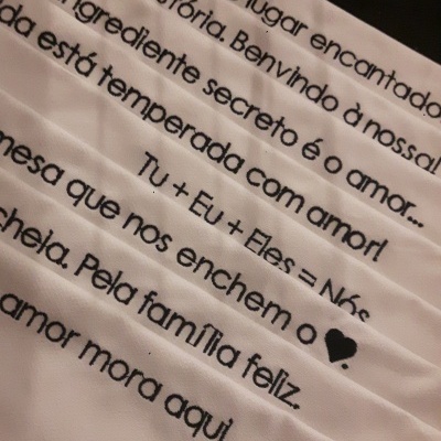 Toalhas brancas com texto impresso em preto sobre fundo escuro