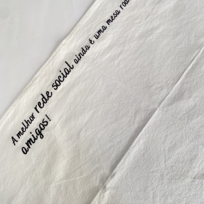 Pano branco com frase bordada a preto