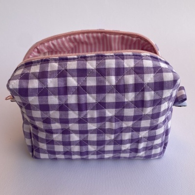 Bolsa xadrez roxa e branca acolchoada com interior rosa às riscas