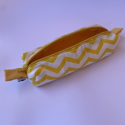 Estojo retangular amarelo e branco com padrão zig zag
