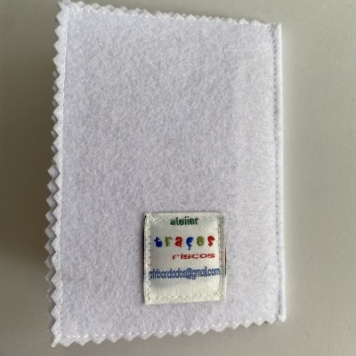 Produto de tecido branco com etiqueta bordada colorida