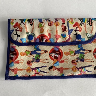 Carteira pequena em tecido com padrão colorido de figuras humanas e fecho azul.