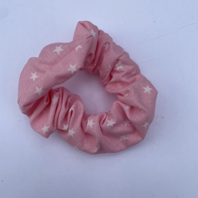 Elástico rosa para cabelo com estrelas brancas sobre fundo branco