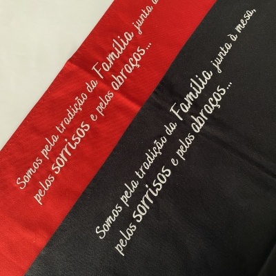 tecidos vermelho e preto com frase bordada em branco