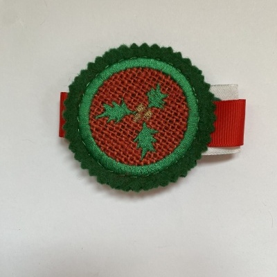 Prendedor decorativo natalício em tecido vermelho e verde com fita vermelha e branca.