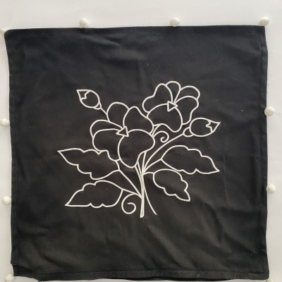Almofada preta com bordado branco de flores e folhas