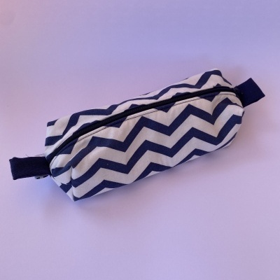 Estojo retangular com padrão zigzag azul e branco e fecho de correr