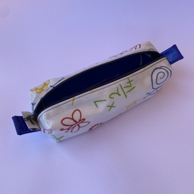 Estojo branco com desenhos coloridos e fecho azul aberto