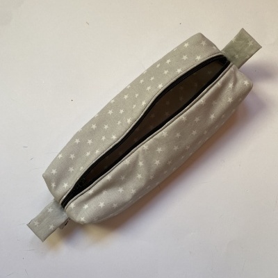 Necessaire cinzenta com estrelas brancas e fecho de correr preto