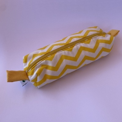 Estojo amarelo e branco com padrão zig zag e fecho de correr amarelo