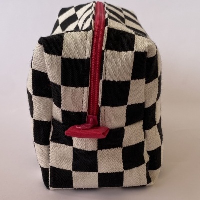 Estojo retangular com padrão xadrez preto e branco e fecho vermelho