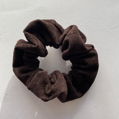 Elástico de cabelo scrunchie castanho escuro de tecido aveludado sobre fundo branco