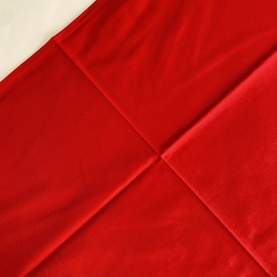 Pano vermelho liso com vincos sobre superfície branca