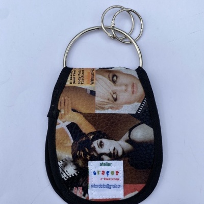 Chaveiro tecido preto com estampas de rostos femininos e argolas metálicas prateadas