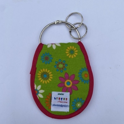 Porta-chaves de tecido com padrão floral colorido e etiquetas visíveis