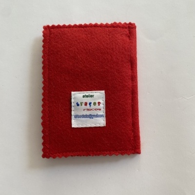 Carteira de feltro vermelho com etiqueta branca colorida