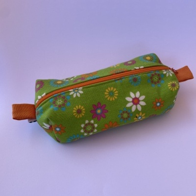 Estojo retangular verde com flores coloridas e fecho laranja