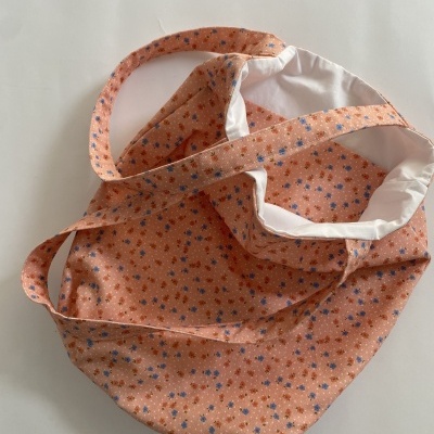 Bolsa em tecido cor de salmão com padrão de pequenas flores e forro branco