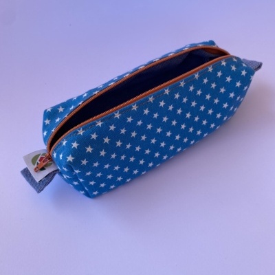 Necessaire azul com estrelas brancas e fecho de correr castanho aberta