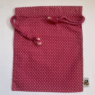 Saco de tecido rosa com estrelas brancas e cordão para fechar.
