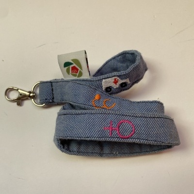 Correia azul de tecido com mosquetão e bordados coloridos