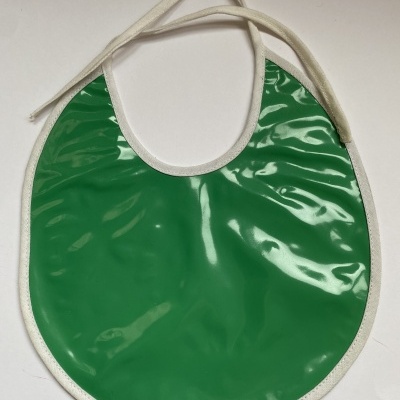 Babete redonda verde com acabamento branco e alças de tecido