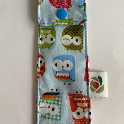 Estojo azul claro com padrão colorido de corujas e fecho azul
